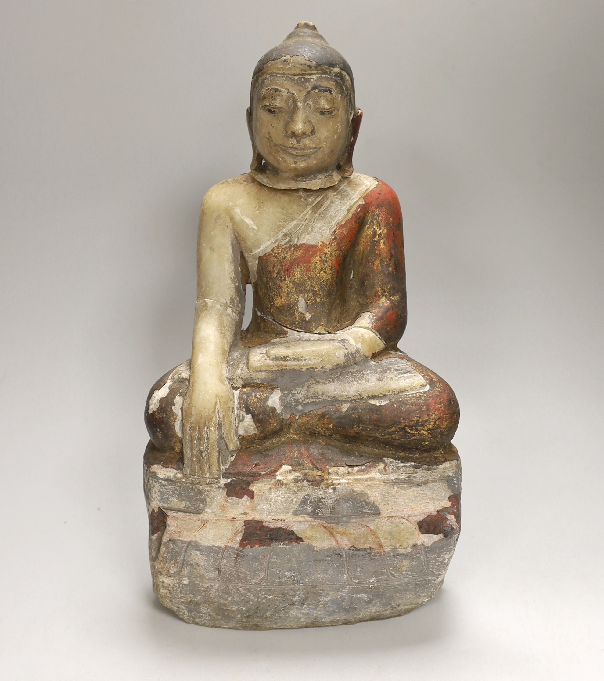 A 19th century Burmese painted alabaster figure of Buddha, damaged, 38cm